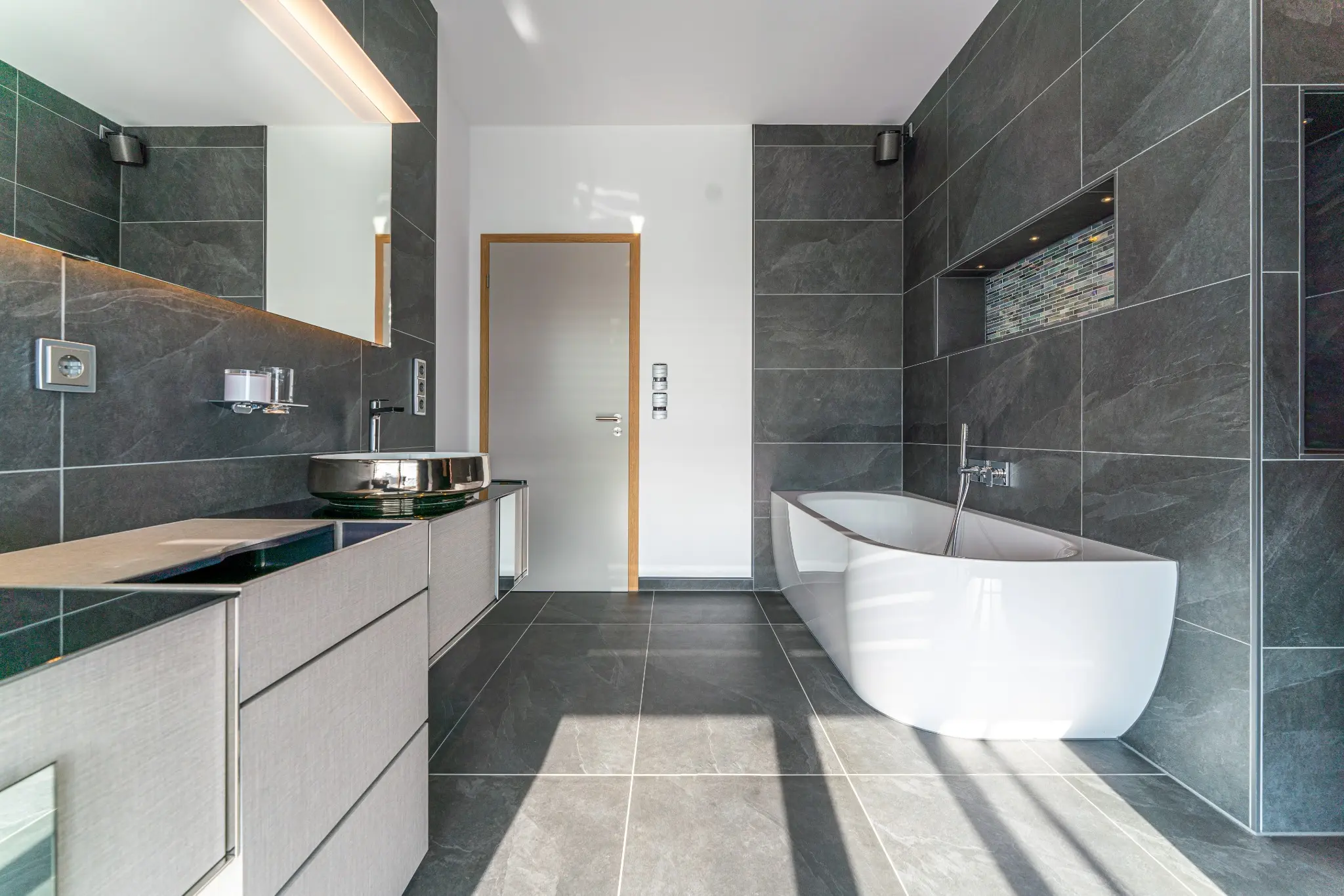 Gesamtansicht des Wellnessbads mit freistehender Badewanne und Doppelwaschplatz