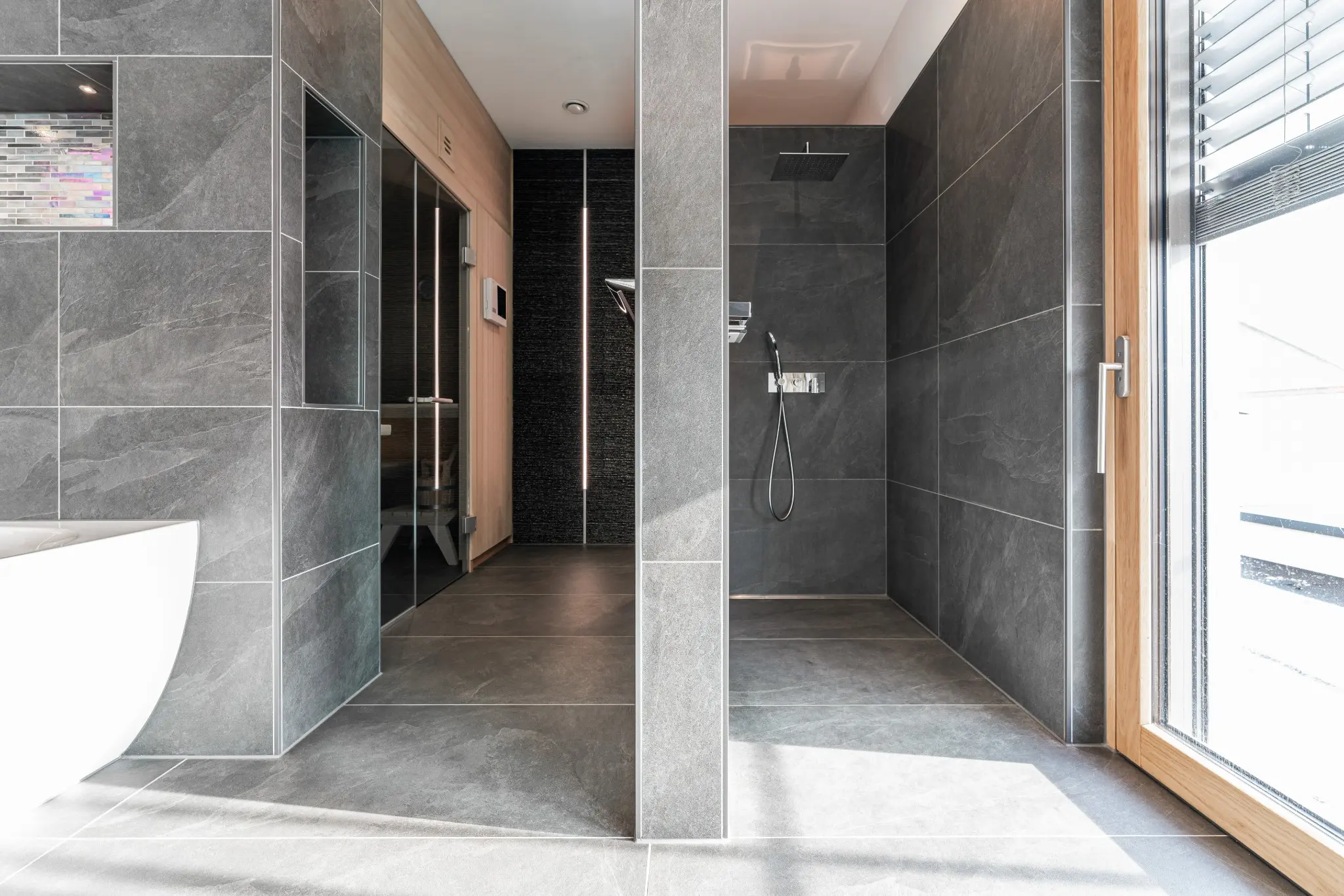 Bodengleiche Dusche und angrenzender Wellnessbereich mit vertikalen Lichtprofilen